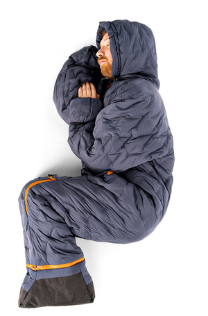 Adult man curled up asleep, wearing a navy blue Selk'bag Nomad full body sleeping bag