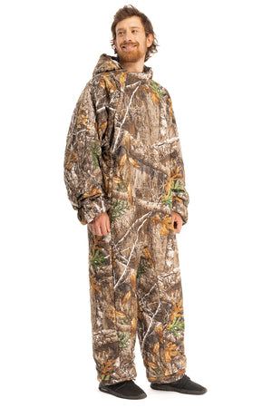 Adult man wearing a Selk'bag Instinct Realtree® EDGE® PERSUIT2 camouflage sleeping bag onesie